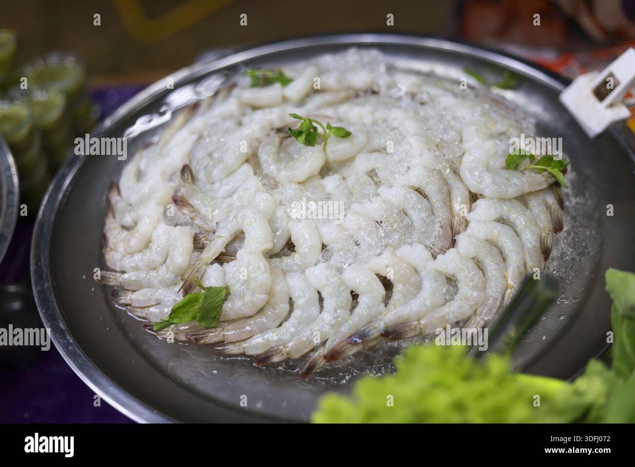 Rohe geschälte weiße Garnelen in frischem Kreismuster auf Metalltablett mit leckerem Look bereit für köstliche Mahlzeiten kochen mit gesunden Zutaten bei l Stockfoto