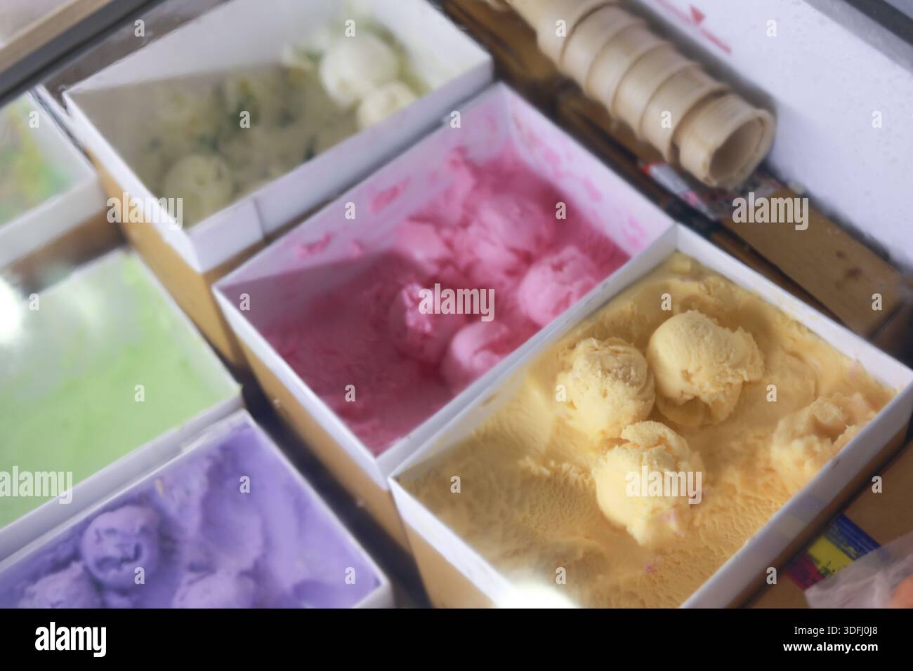 Lebendige Schaufel mit köstlichem hausgemachtem Eis in einem Karton mit süßem, erfrischendem Dessert mit verschiedenen Aromen und Farben wie Beere va Stockfoto