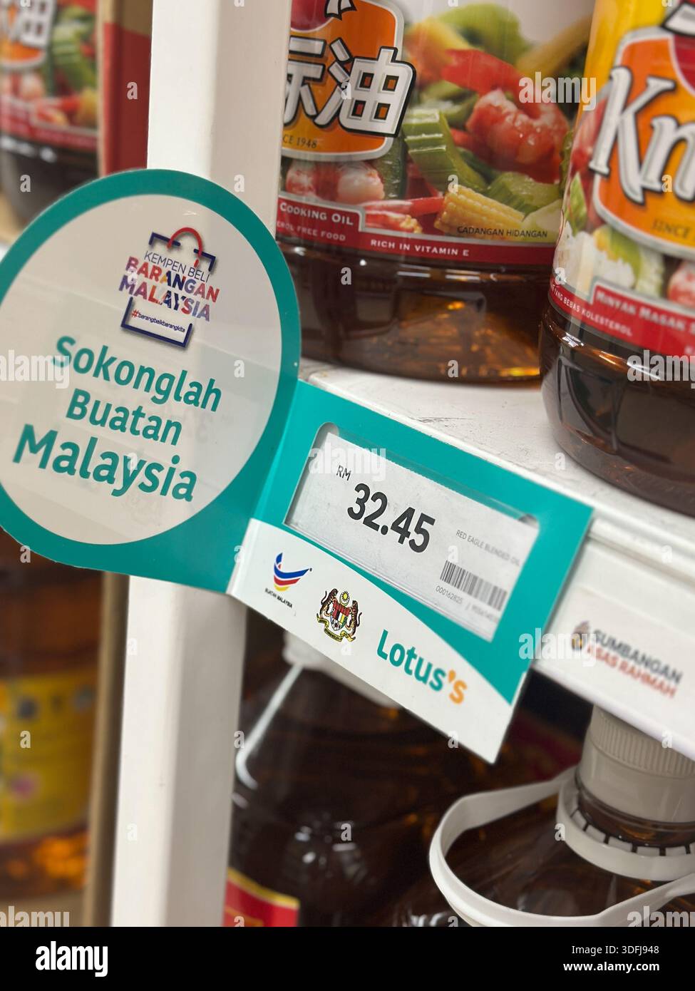 Johor, Malaysia, 21. Dezember 2025: Regalpräsentation von Red Eagle Kochöl mit malaysischer Produktkampagne und Preisgestaltung im Supermarkt von Lotus. Stockfoto