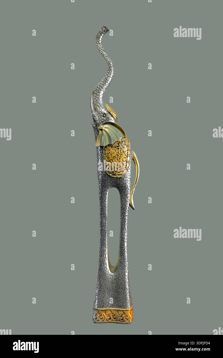 Eine hohe, antike Elefantenskulptur mit verzierten Golddetails und einer zerrissenen Textur auf isoliertem grünem Hintergrund mit Beschneidungspfad. Stockfoto