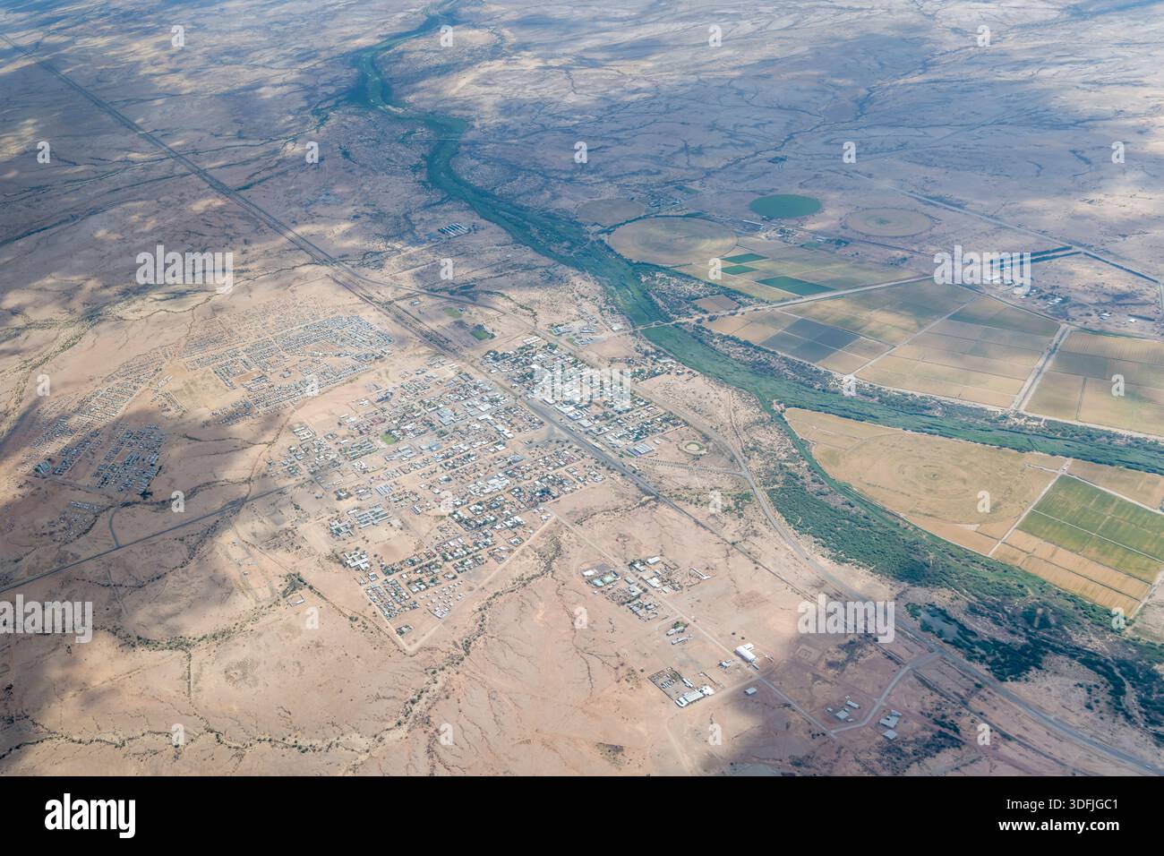 Luftbild von Nordosten mit Mariental Town und Township in karger Landschaft, aufgenommen von einem Segelflugzeug im hellen Licht des späten Frühlings, Hardap, Stockfoto