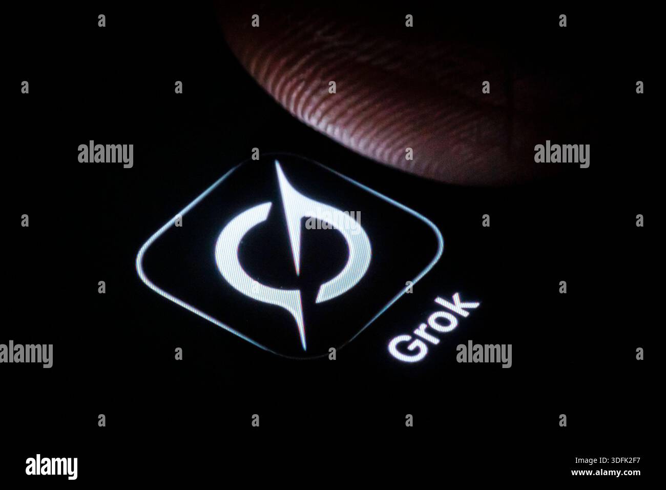 Symbolfoto: Das Logo des KI-Chatbot Grok von XAI ist neben einem Finger auf dem Display eines Smartphones zu sehen. Berlin, 13.01.2026. Berlin Deutsch Stockfoto