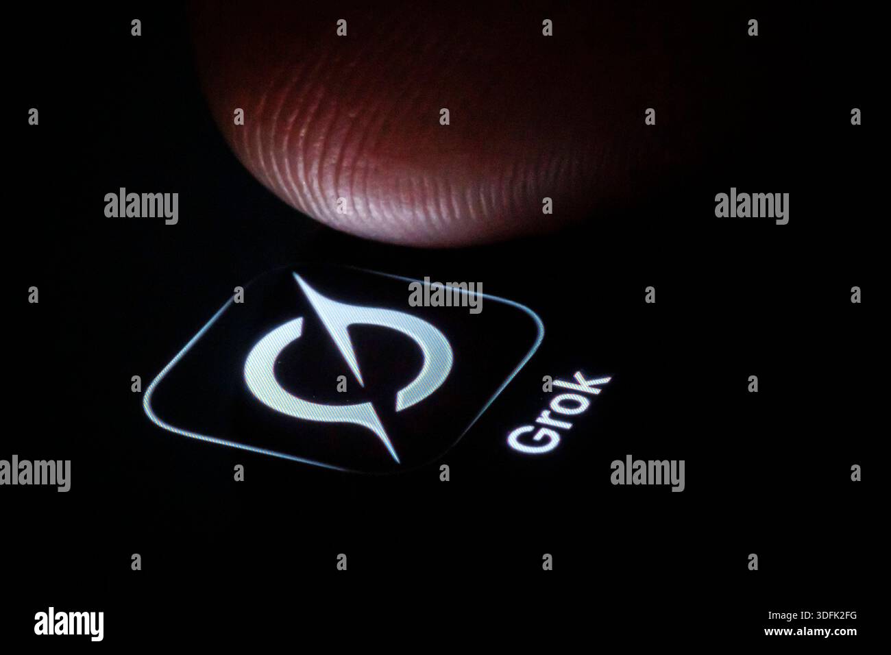 Symbolfoto: Das Logo des KI-Chatbot Grok von XAI ist neben einem Finger auf dem Display eines Smartphones zu sehen. Berlin, 13.01.2026. Berlin Deutsch Stockfoto