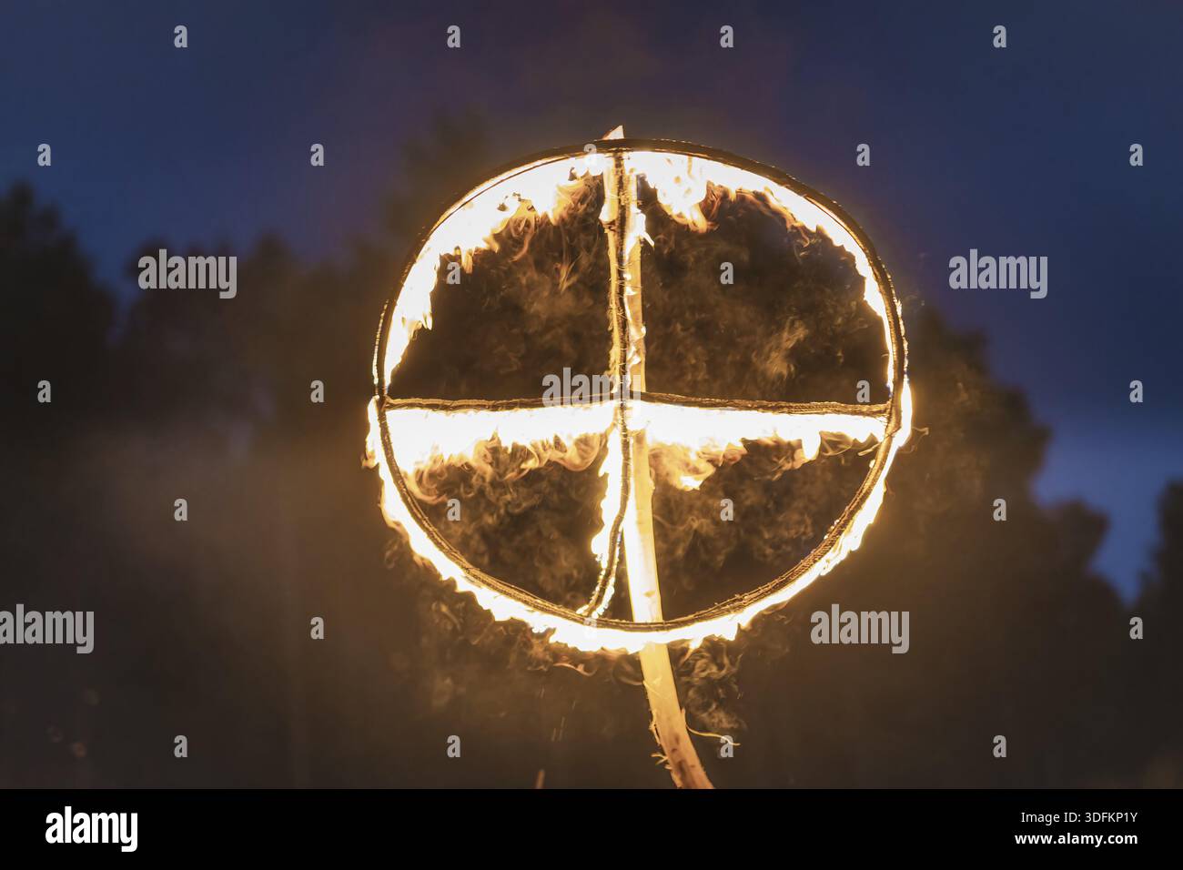 Brennendes Symbol der Sonne, ein Sonnenkreuz oder Sonnenrad bei heidnischer Nachstellung der Kupala-Nacht, in Polen Noc Kupaly genannt. Slawischer Feiertag wird gefeiert Stockfoto