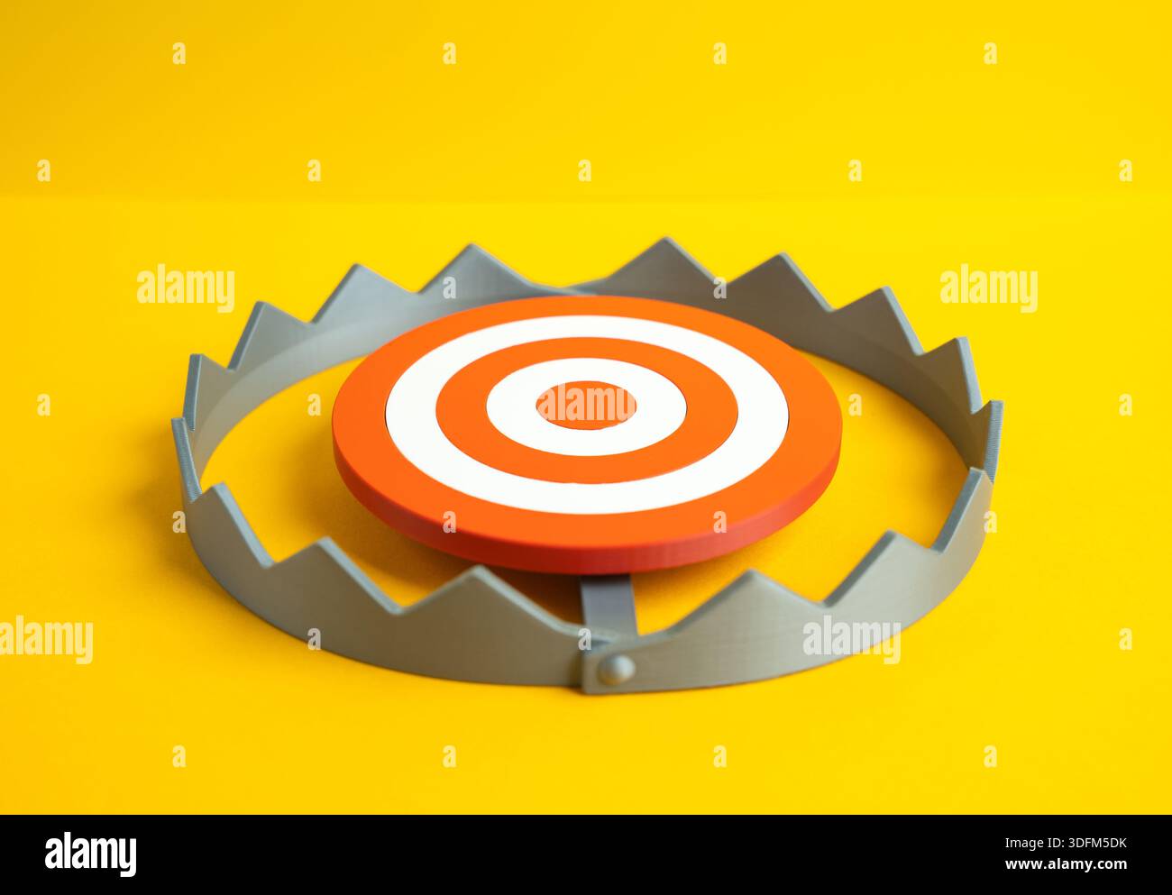 Ein rundes Ziel in der Mitte einer Falle. Die Gefahr, in eine Falle zu fallen und zu versagen, zu verstehen. Symbol für strategisches Risiko, falsche Ziele und Druck Stockfoto
