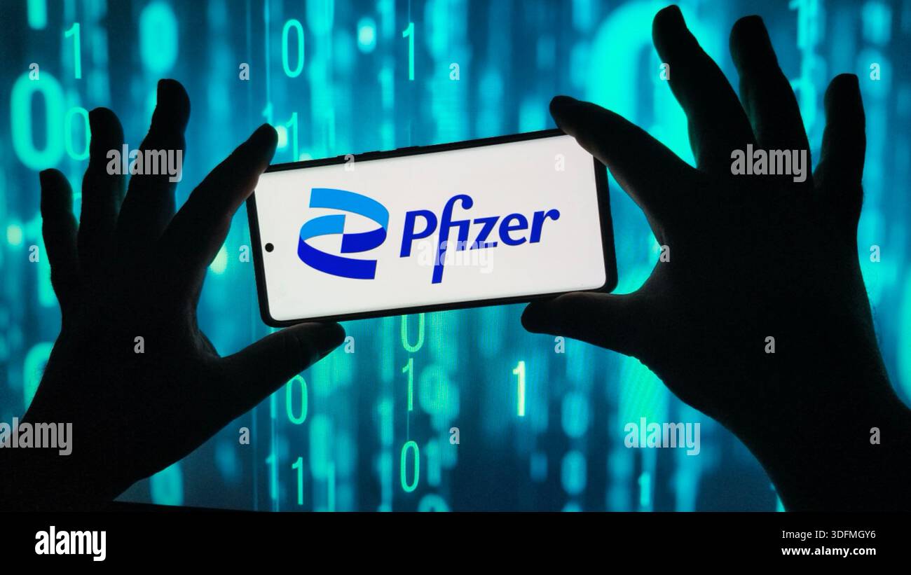 Silhouettenzeiger halten ein Smartphone mit dem Pfizer-Logo vor einem digitalen Datenhintergrund. - Smartphone-aufgenommenes Stockfoto