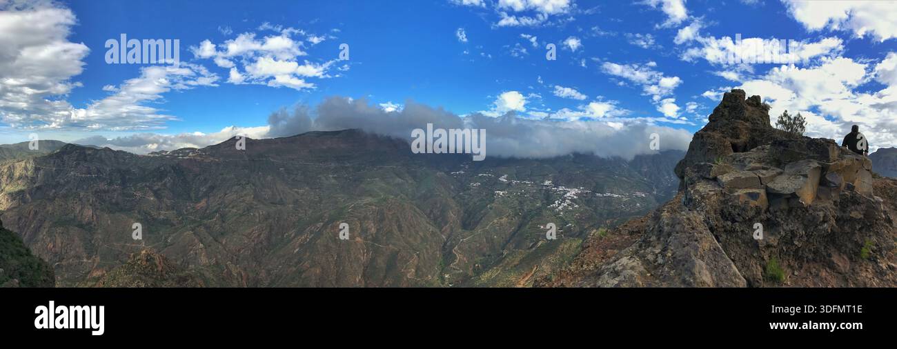 Panoramablick auf ein beeindruckendes Berggelände unter einem dynamischen bewölkten Himmel, das die lebendige natürliche Schönheit und die rauen geografischen Merkmale zeigt. Idee Stockfoto