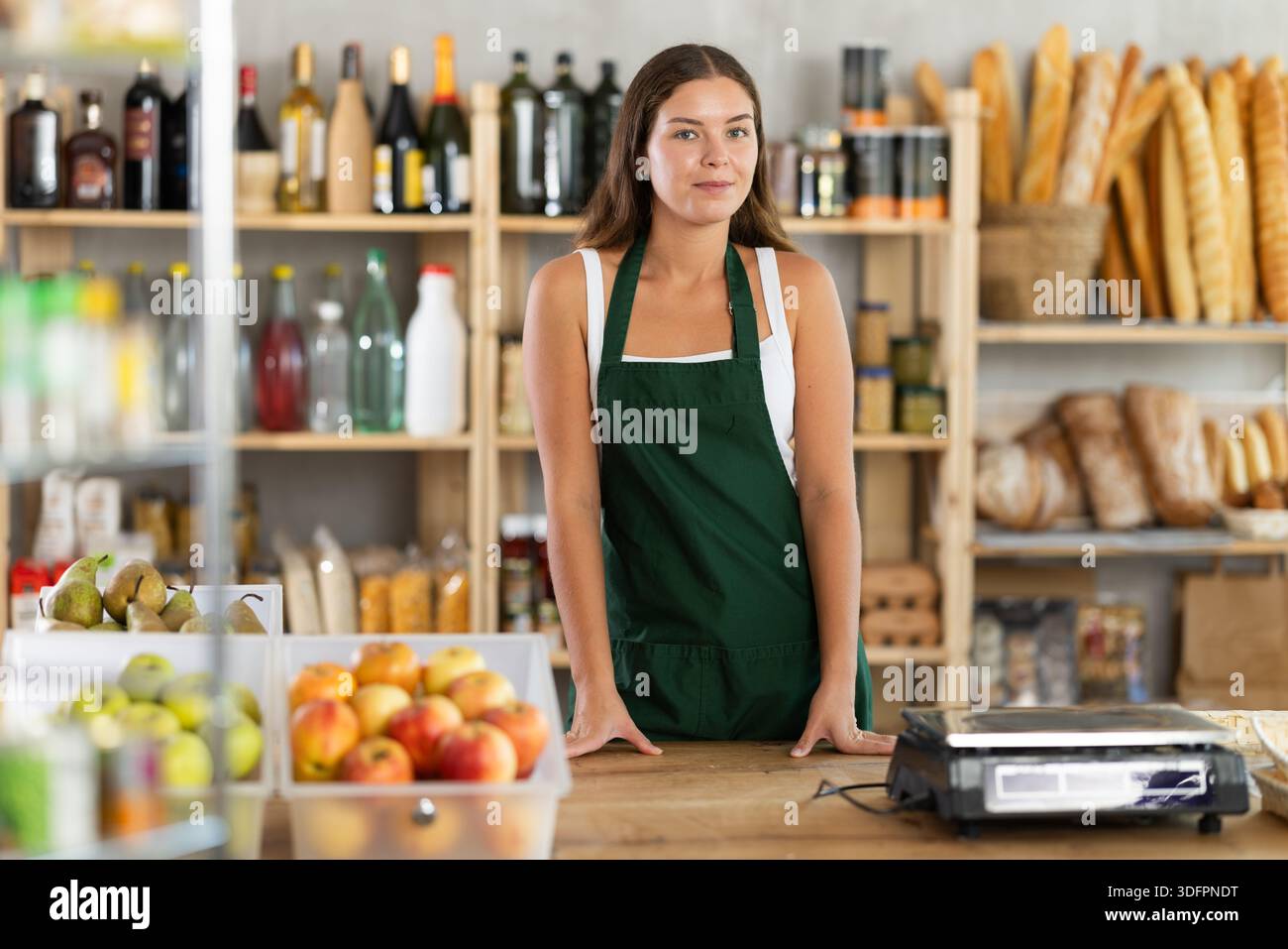 Porträt einer lächelnden Verkäuferin auf der Schürze hinter dem Supermarkt Stockfoto