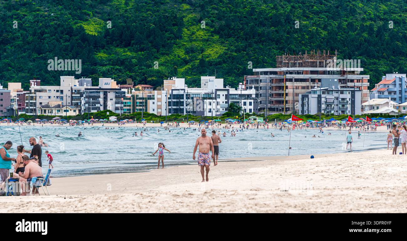 Praia de Palmas Strand mit städtischer Küste und grünen Hügeln, Brasilien Stockfoto