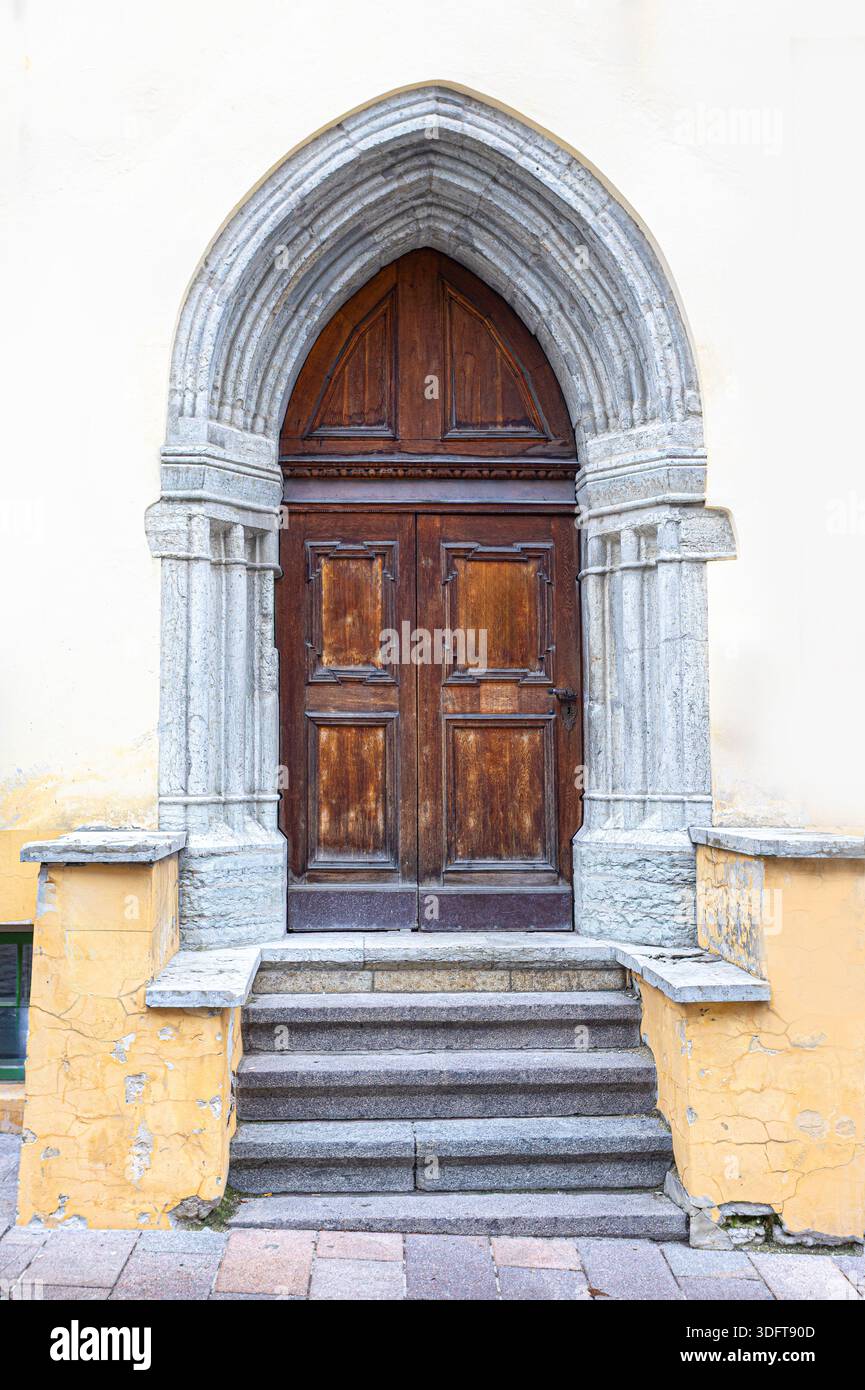 Altstadt tallinns mittelalterlicher Steinbogen, der eine Holztür mit Stufen umrahmt Stockfoto