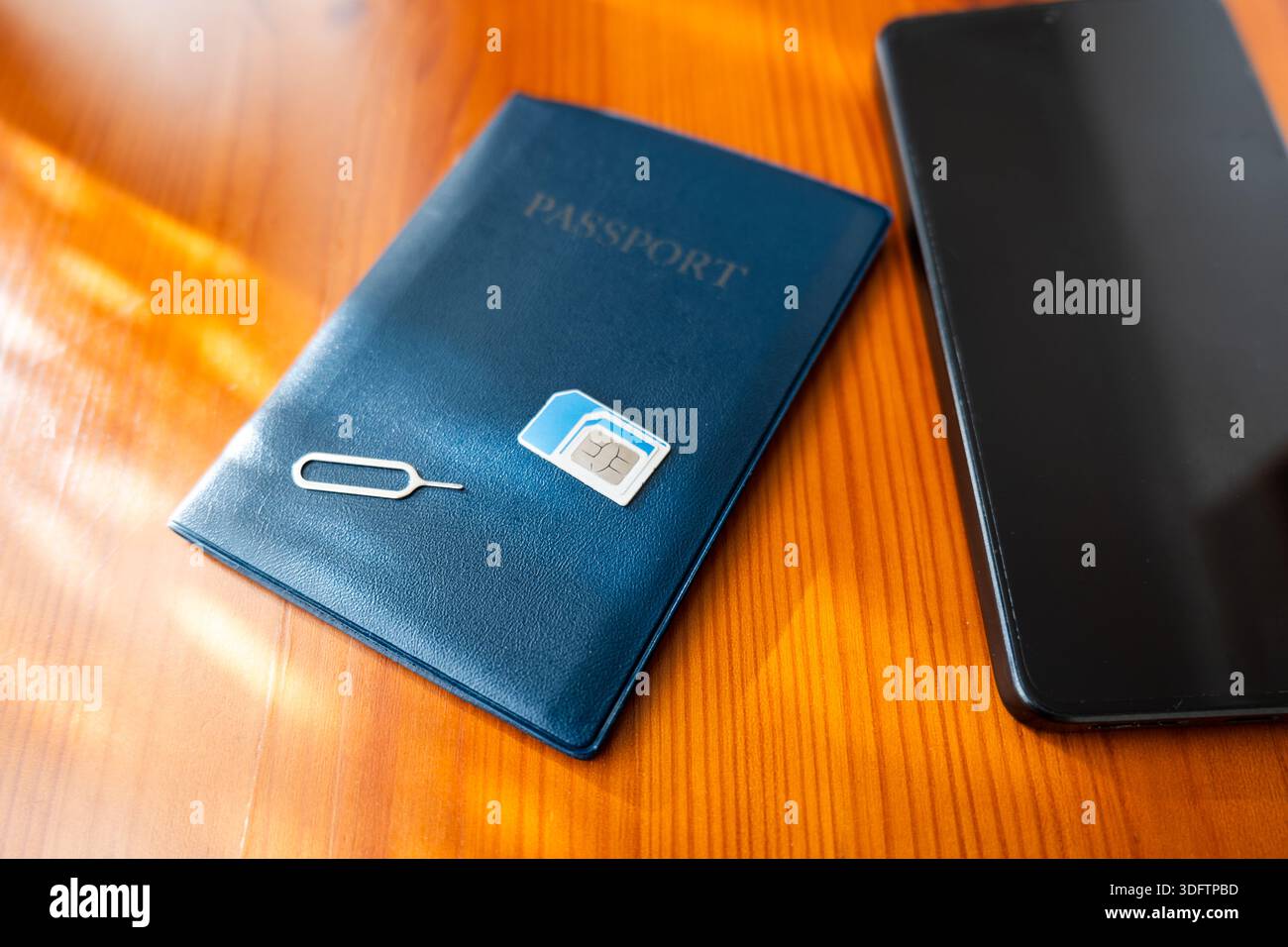 SIM-Karte und Reisepass neben dem Smartphone. sim-Karte auf Pass, Nahaufnahme Stockfoto