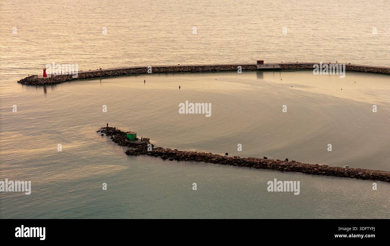 Drohnenblick auf den Morgensonnenaufgang über einer ruhigen Meeresbucht Stockfoto