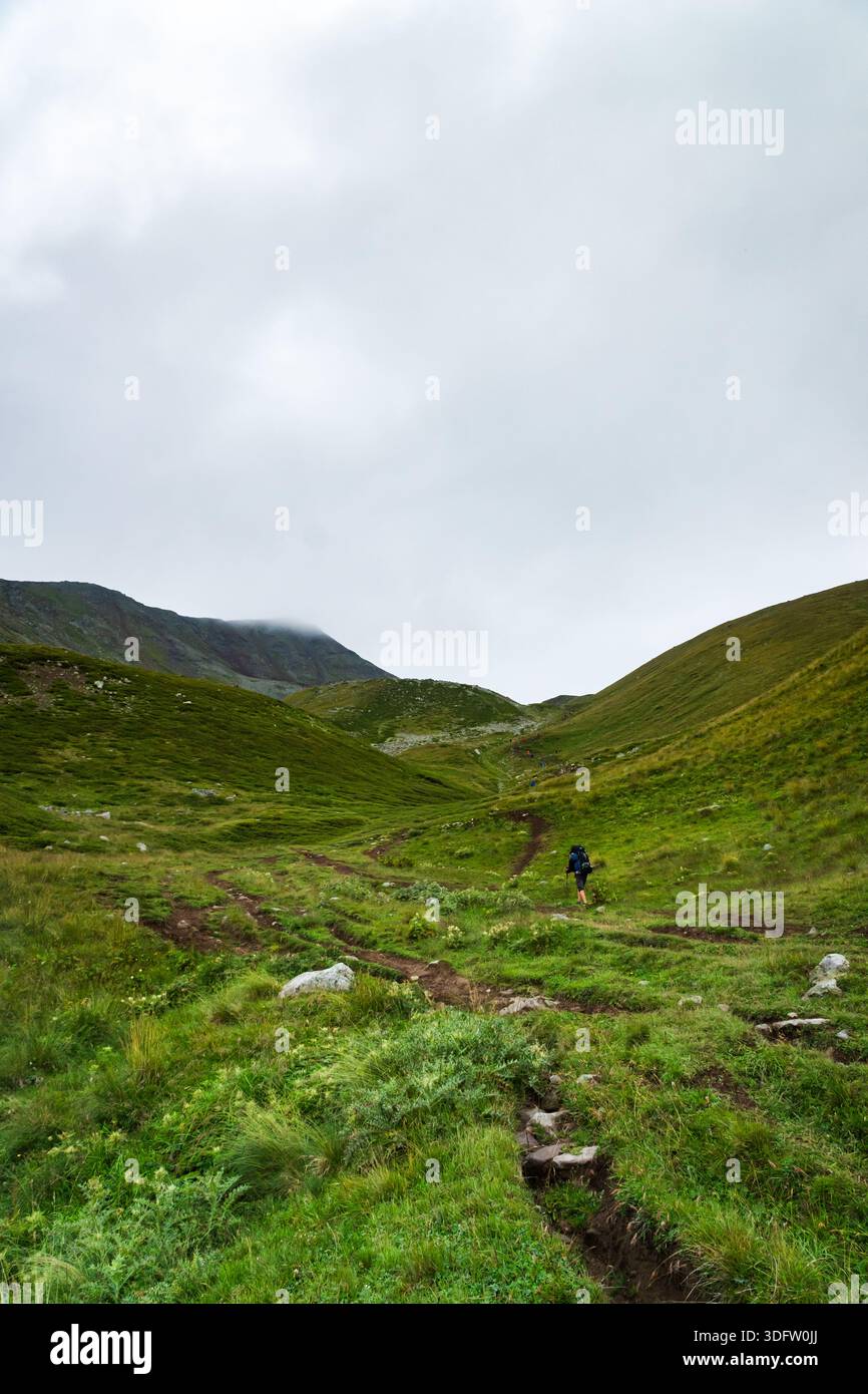 Wandern bei schlechtem Wetter mit bewölktem und regnerischem kaltem Wetter. Bergwandern bei widrigen Bedingungen mit Wolken, Wind, Regen. Stockfoto