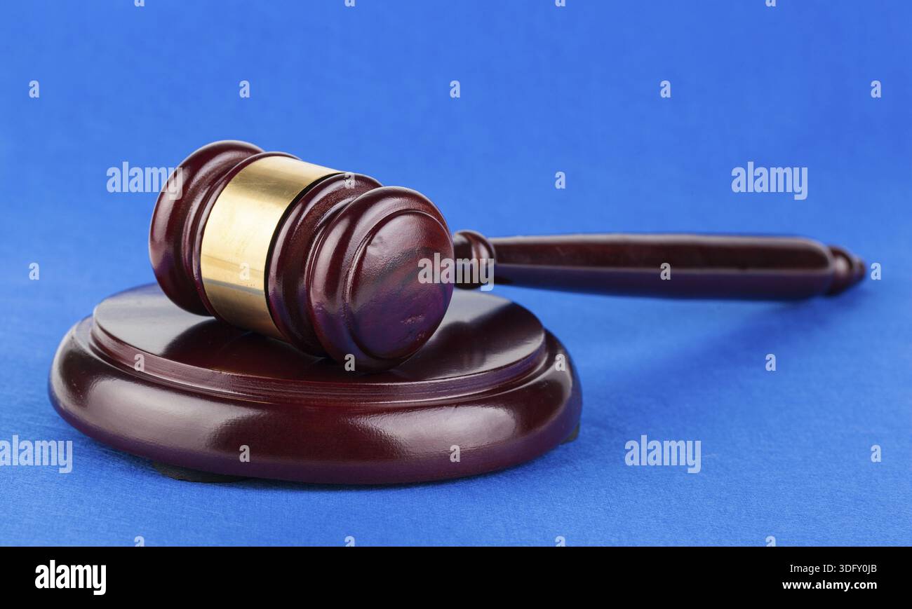 Hölzerner brauner Richter-Hammer auf blauem Hintergrund Stockfoto