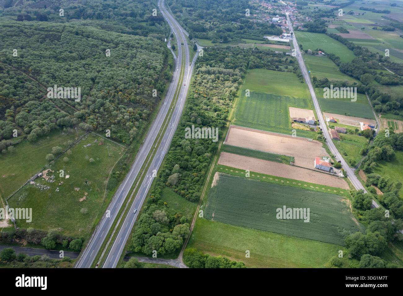 6. Blick auf eine stark befahrene Autobahn mit Verkehr neben einem grünen Wald Stockfoto