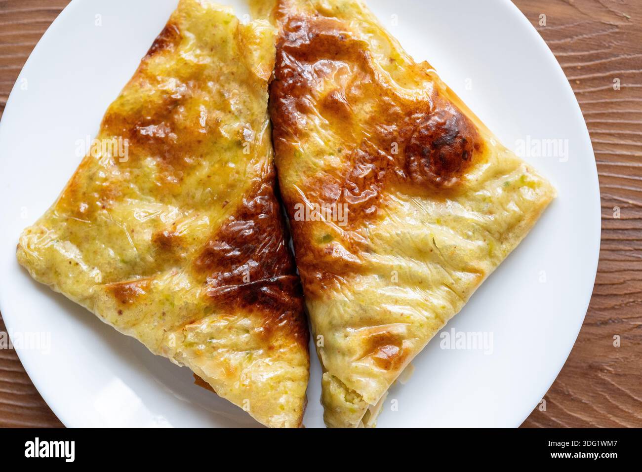 Nahaufnahme von traditionellem türkischem Katmer-Gebäck mit Pistazien, serviert neben süßem Baklava Stockfoto
