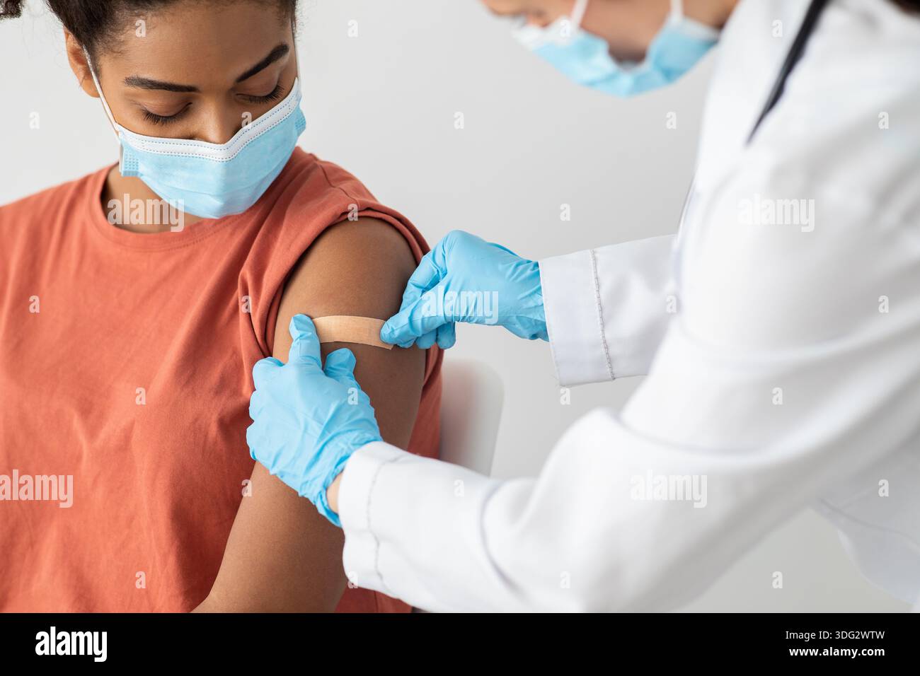 Krankenschwester, die medizinischen Pflaster auf den weiblichen Patientenarm legt Stockfoto
