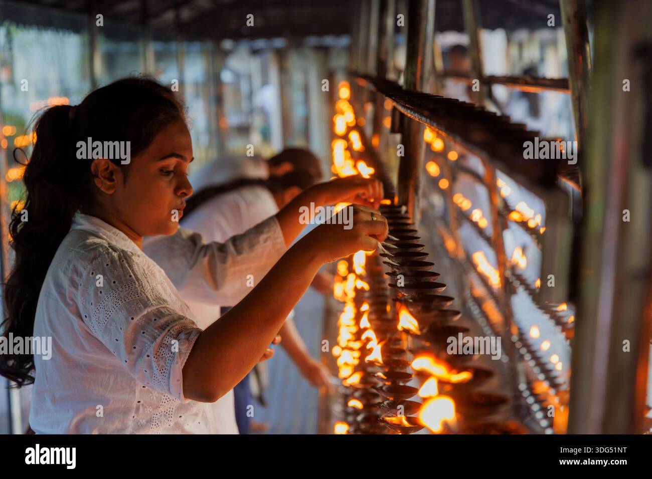 Pilger zünden Öllampen während des Gebets im Tempel des Heiligen Zahns (Sri Dalada Maligawa), Kandy, Sri Lanka Stockfoto