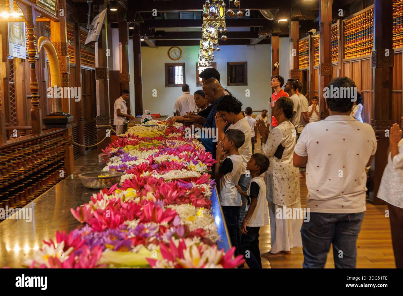 Pilger beten mit Lotusblumen im Tempel des Heiligen Zahns (Sri Dalada Maligawa), Kandy, Sri Lanka Stockfoto