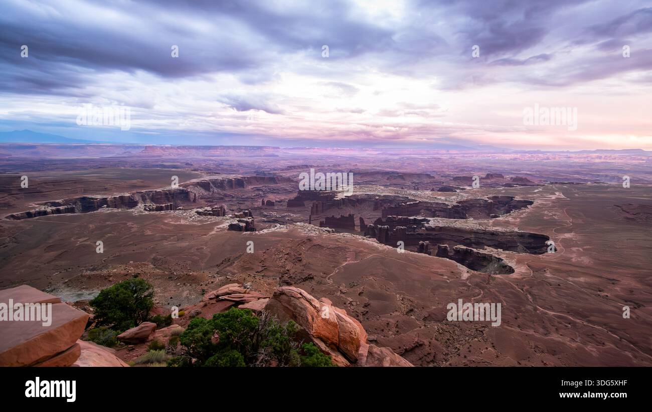 Weitläufiger Panoramablick auf die geschichteten Canyonlands unter dem dramatischen Sonnenuntergang im Canyonlands National Park Stockfoto
