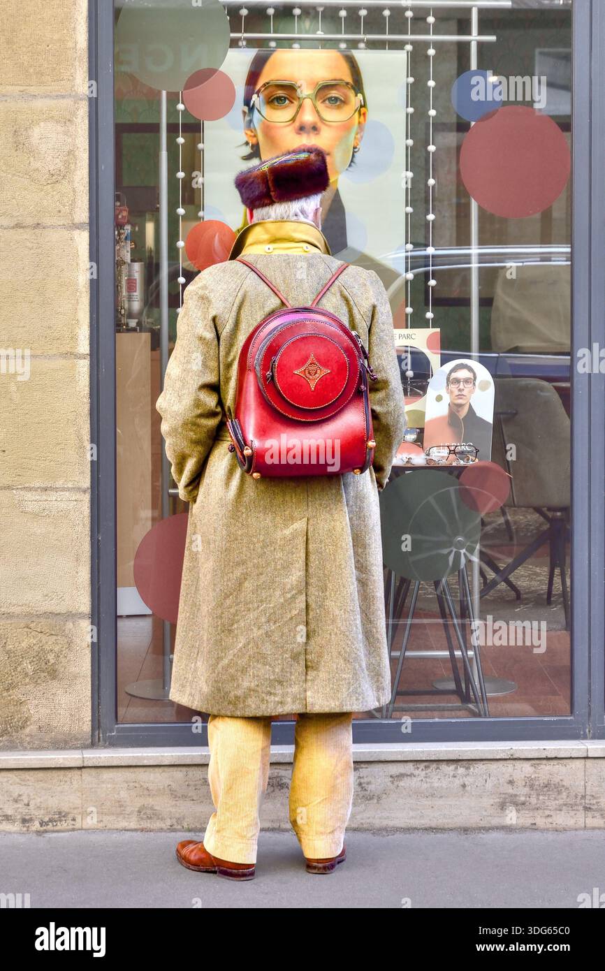 Mann mit russischem Pelzhut / Uschanka und Lederrucksack, der in das Schaufenster blickt - Tours, Indre-et-Loire (37), Frankreich. Stockfoto