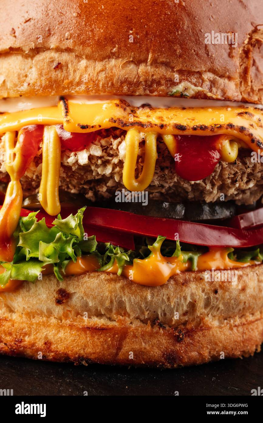 Ultra-Nahaufnahme eines saftigen Burgers mit Schichten Rindfleisch, geschmolzenem Käse, frischem Gemüse und einem gerösteten Brötchen, gekrönt mit einem dicken Deckel VI Stockfoto
