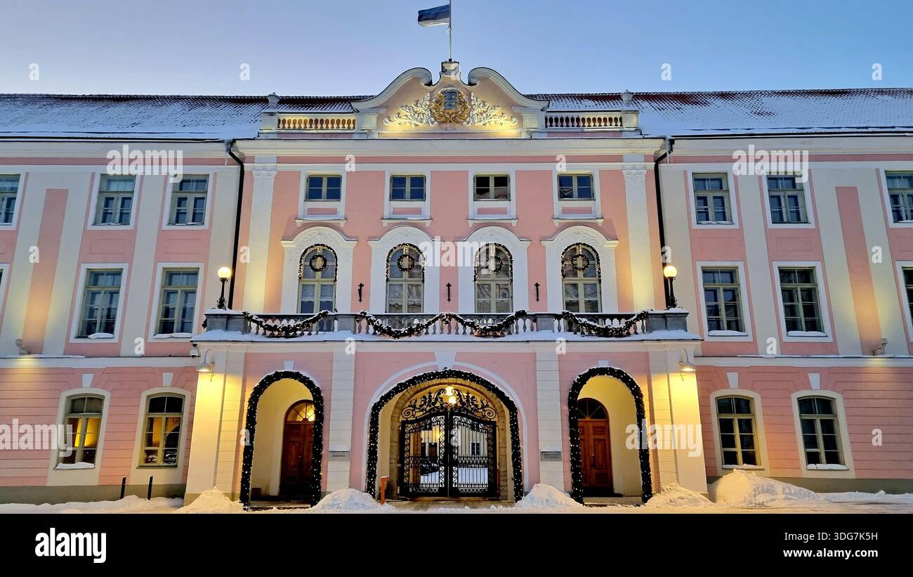 Blick auf die festlich beleuchtete rosa-weiße Fassade des Hauptgebäudes des estnischen Parlaments und Schneeschwankungen im Vordergrund. Tallinn, Estland Stockfoto
