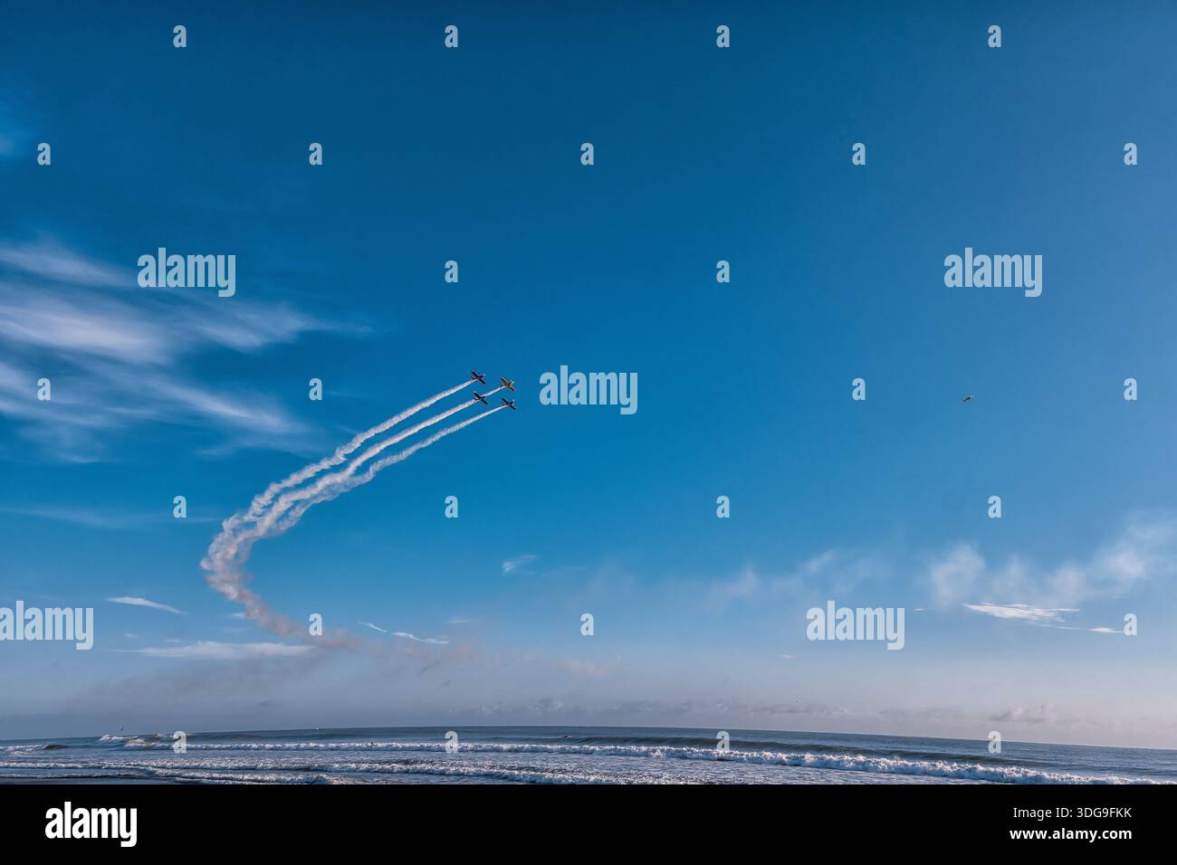 Drei Flugzeuge fliegen am Himmel mit Rauchspuren dahinter. Der Himmel ist klar und blau ohne Wolken Stockfoto
