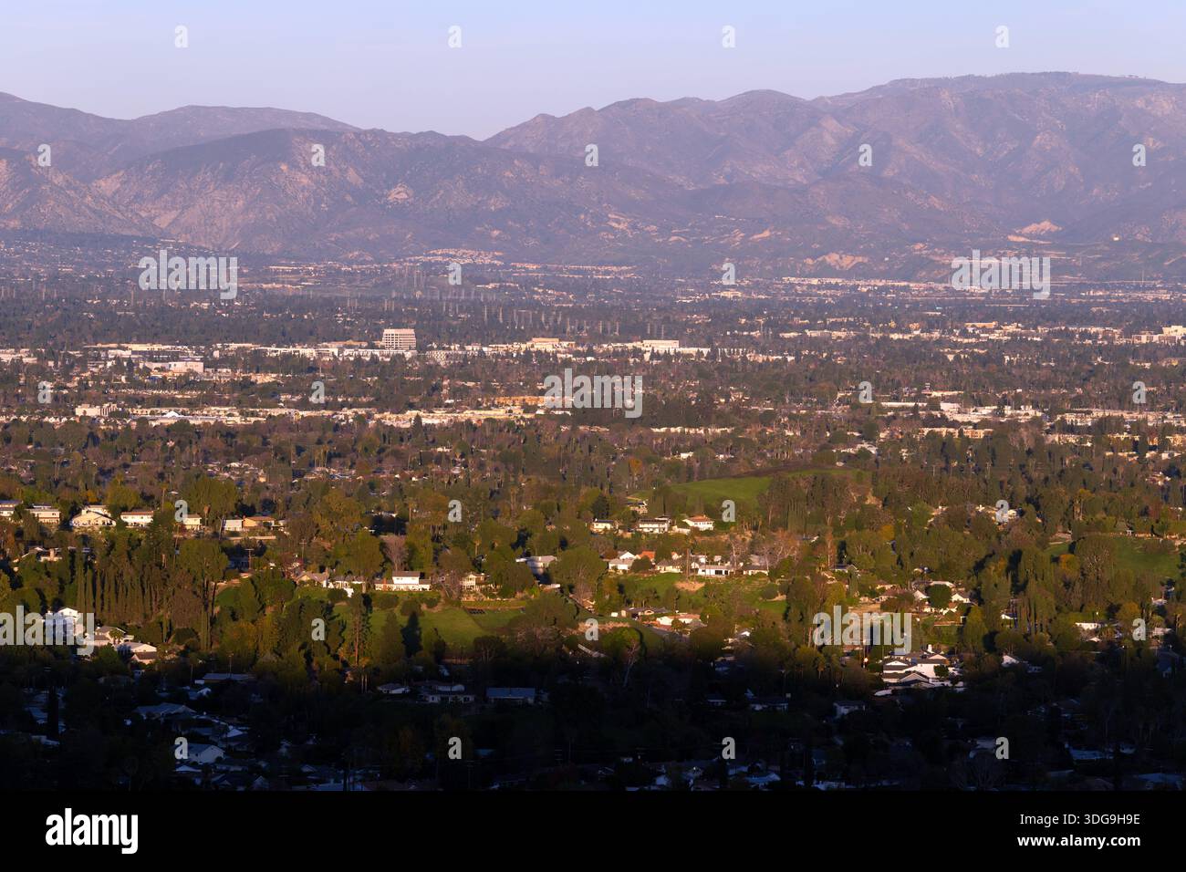 Weite Aussicht über das San Fernando Valley in Richtung der San Gabriel Mountains, mit dichten Vorstadtvierteln und Licht am späten Nachmittag. Stockfoto