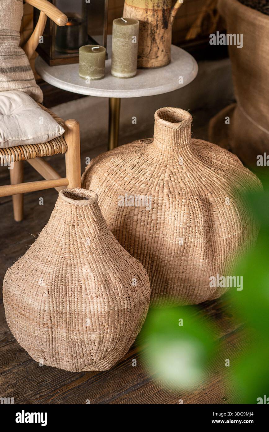 Ein Paar handgefertigter gewebter Strohvasen oder Korbvasen mit einzigartigen abgerundeten Silhouetten, die natürliche Texturen und traditionelle Handwerkskunst zeigen. Stockfoto