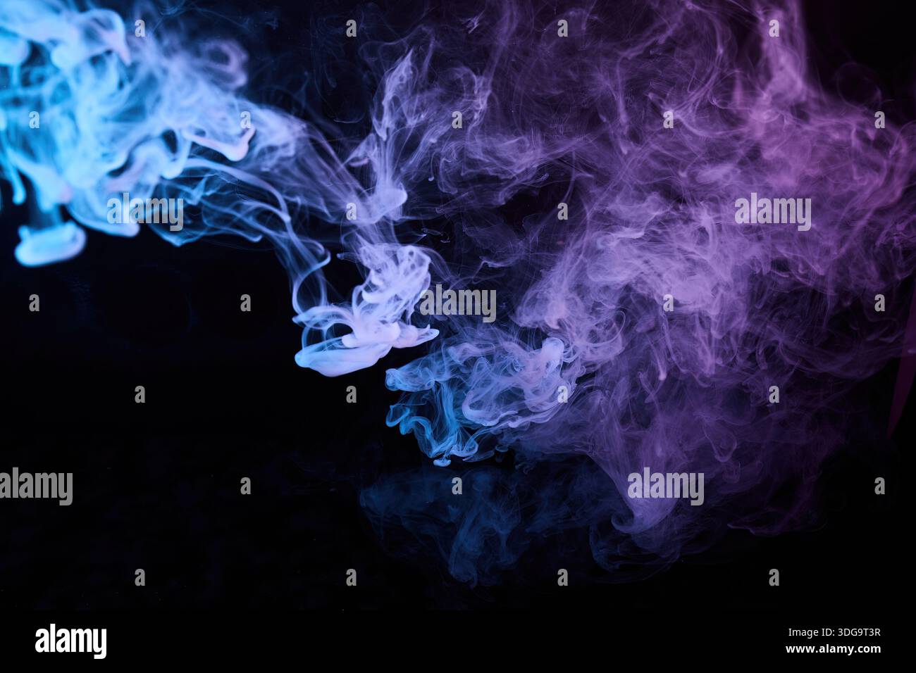 Farbenfroher Rauch, der blaue und violette Dämpfe mischt Stockfoto