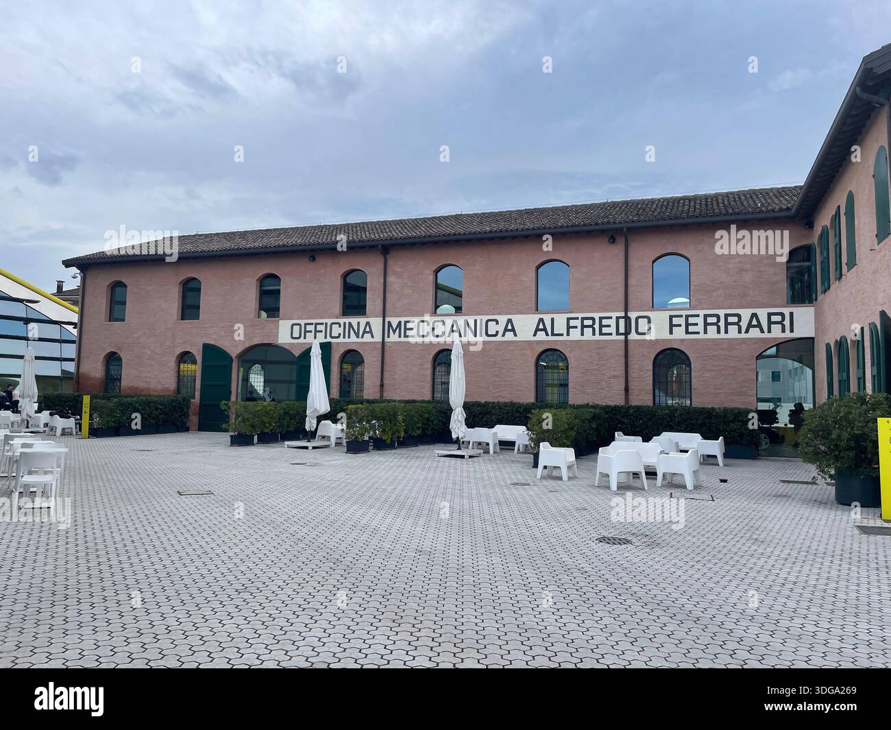 Historisches Backsteinfabrikgebäude in Italien mit Industriehof, ehemaliger mechanischer Werkstatt, die als Kultur- und Designraum wiedergenutzt wurde - Smartphone-aufgenommenes Stockfoto