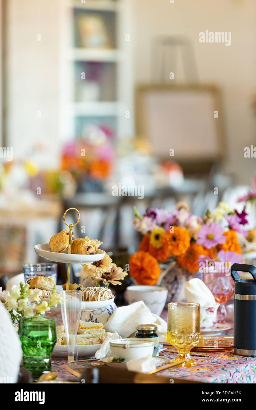 Brunch-Tisch mit Gebäckturm, Blumenstrauß und farbenfrohen Farben Stockfoto
