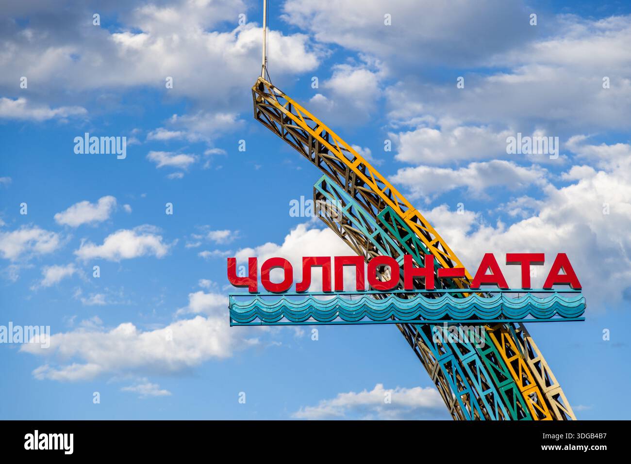 Große Metallstruktur mit Begrüßungsschild für die Stadt Cholpon-ATA am Issyk-Kul-See in Kirgisistan an sonnigen Tagen. Stockfoto