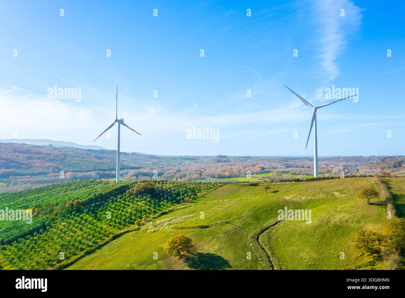 Luftaufnahme von Windturbinen, die die Energiewende auf grünen Hügeln vorantreiben und erneuerbare Energie für eine kohlenstofffreie Zukunft und nachhaltiges DE produzieren Stockfoto