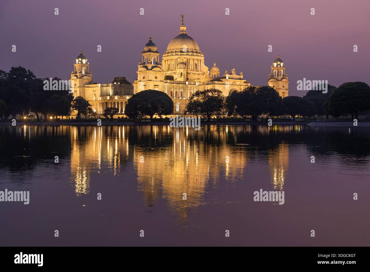 Das Victoria Memorial erleuchtete in der Abenddämmerung und spiegelte sich im See in Kalkutta, Westbengalen, Indien Stockfoto