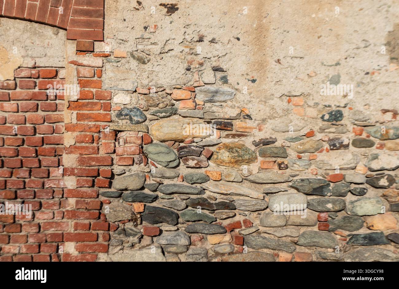 Alte Ziegelstein- und Steinmauer mit mehrschichtigen Texturen und verwitterten Oberflächen, perfekt als architektonischer Hintergrund für Design, Restaurationskonzepte und ur Stockfoto