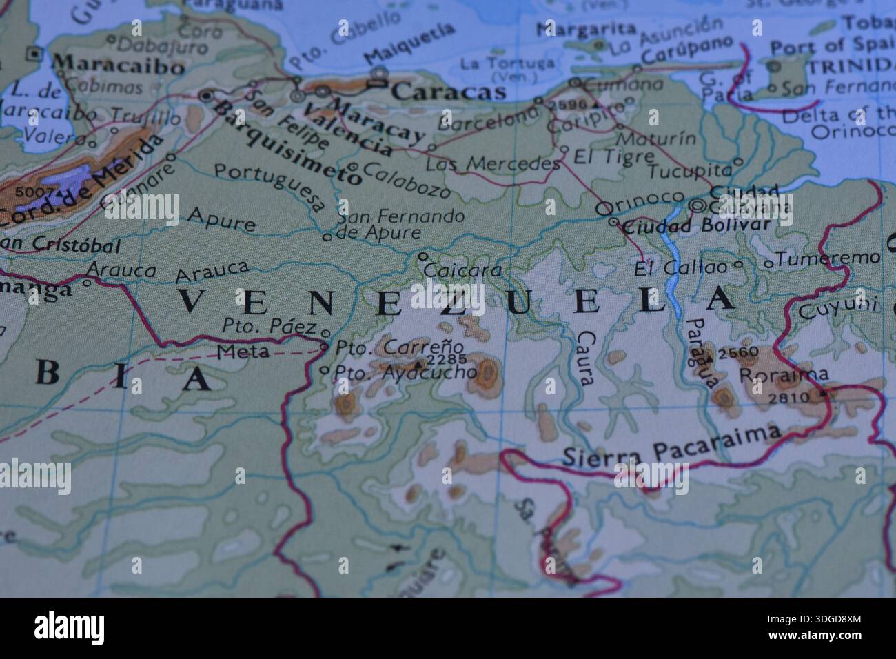 Makroaufnahme einer physischen Karte Venezuelas, die Caracas, Maracaibo und den Orinoco-Fluss sowie Grenzen und Gebirgszüge zeigt. Stockfoto