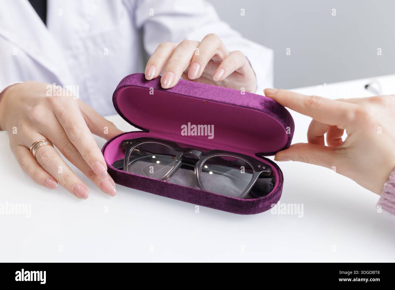 Nahaufnahme der Optiker- und Kundenbrille in einer Schutzhülle für die Brillenauswahl, ideal für Website- oder Klinikbroschüren. Stockfoto