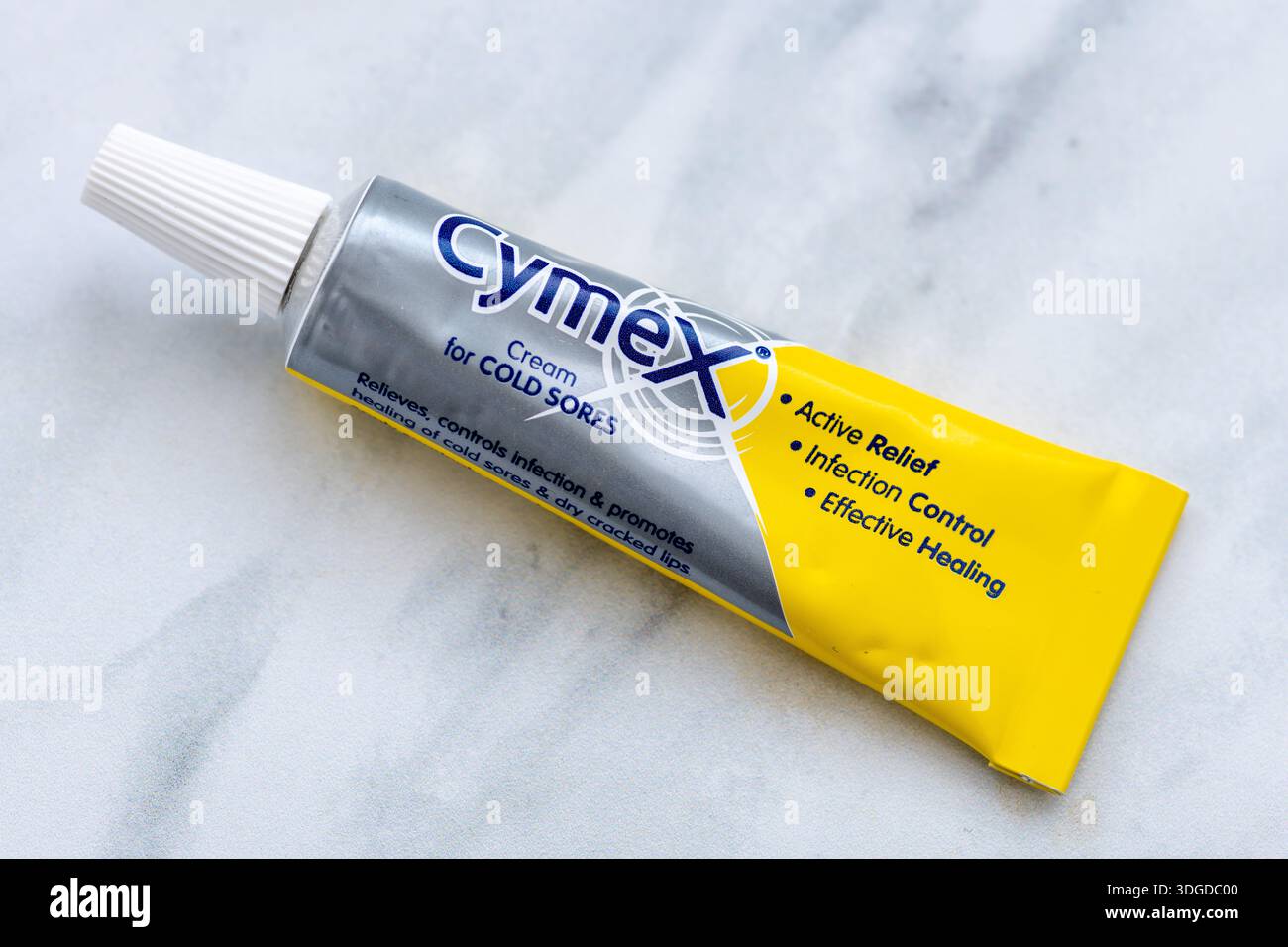 London. UK - 14. Januar 2026. Eine Makronaht einer Tube Cymex-Creme zur Behandlung von Infektionen mit Kaltbläschen, isoliert auf einem weißen Marmorhintergrund Stockfoto