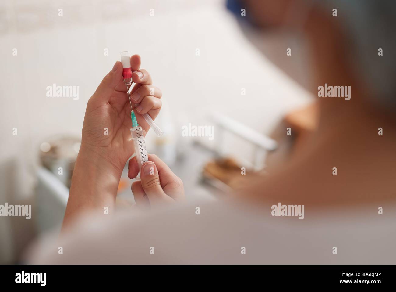 Eine Ärztin zieht ein Medikament in eine Spritze, selektiver Fokus. Stockfoto