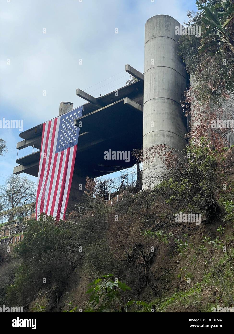 Amerikanische Flagge über dem berühmten Los Angeles Haus nach dem Palisades Feuer Stockfoto