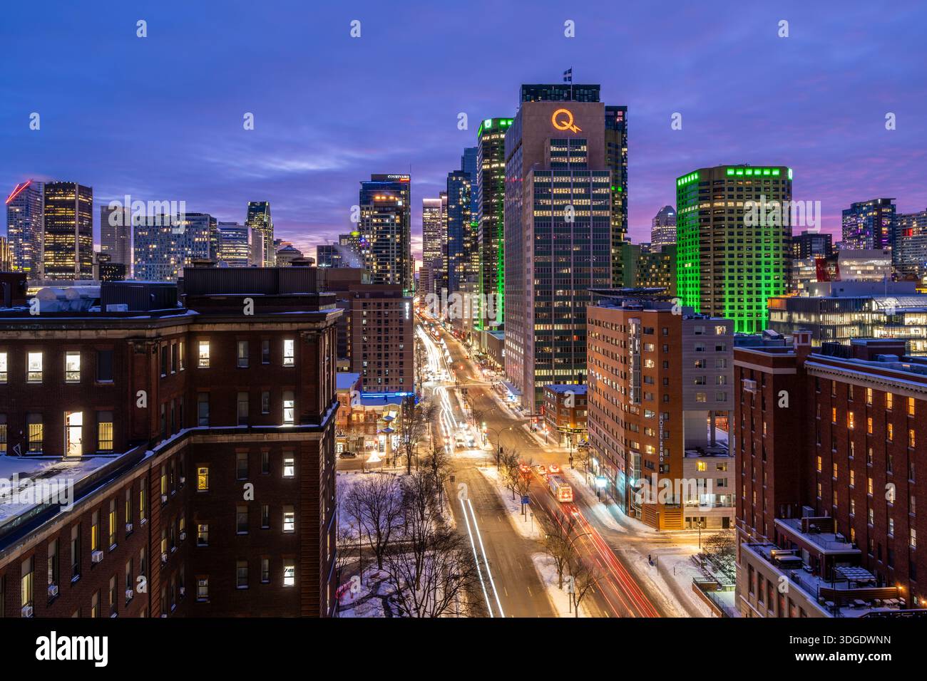 Montreal, QC - 2. Januar 2026: Eine farbenfrohe Langzeitbelichtung der Skyline von Montreal in der Abenddämmerung mit beleuchteten Wolkenkratzern und Autolichtern in Zeitlupe Stockfoto