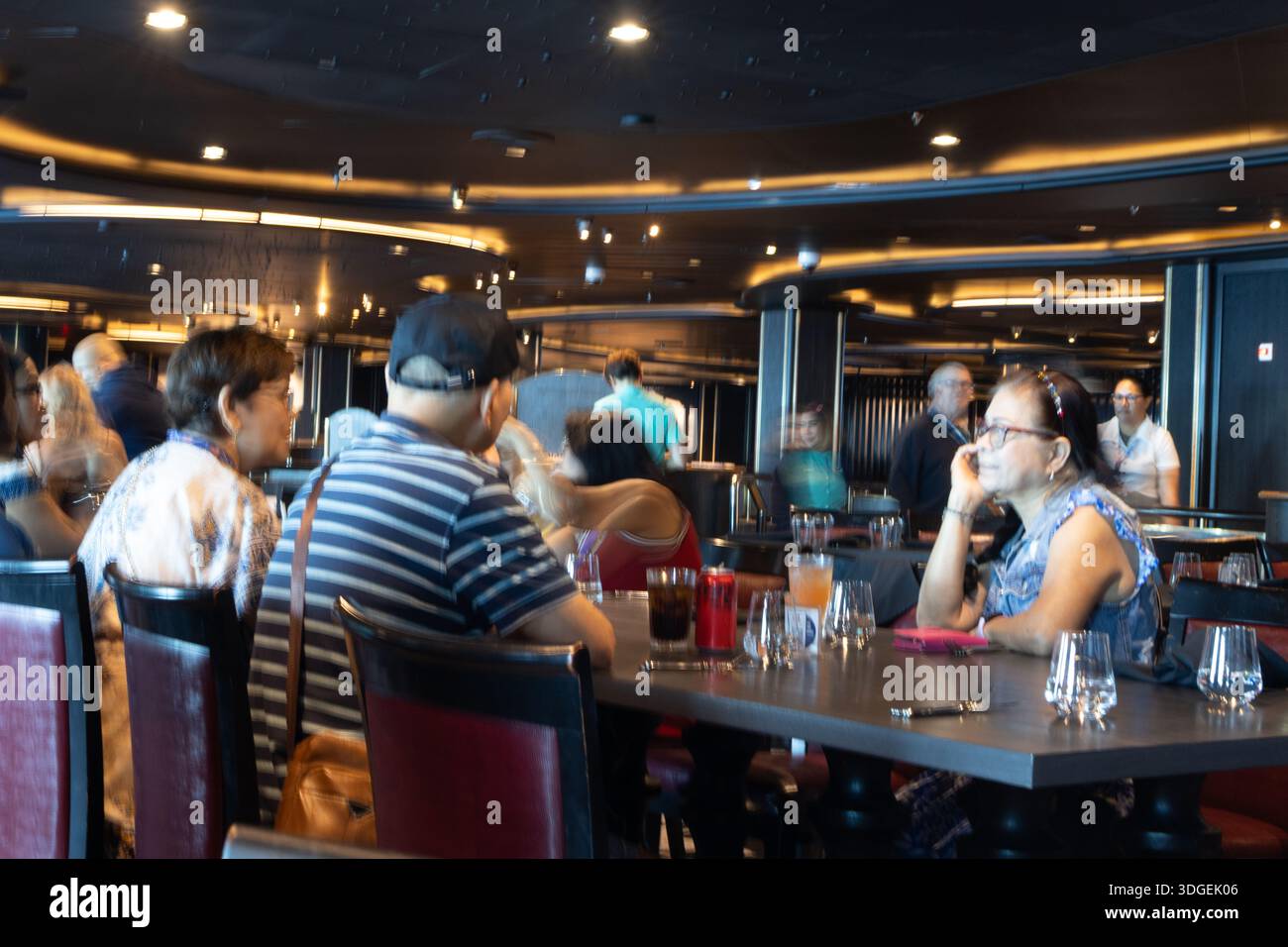 Die Passagiere treffen sich in einem Kreuzfahrtschiff und nutzen gemeinsame Innenräume, die für Entspannung, Essen und Unterhaltung während einer Reise ausgelegt sind. Stockfoto