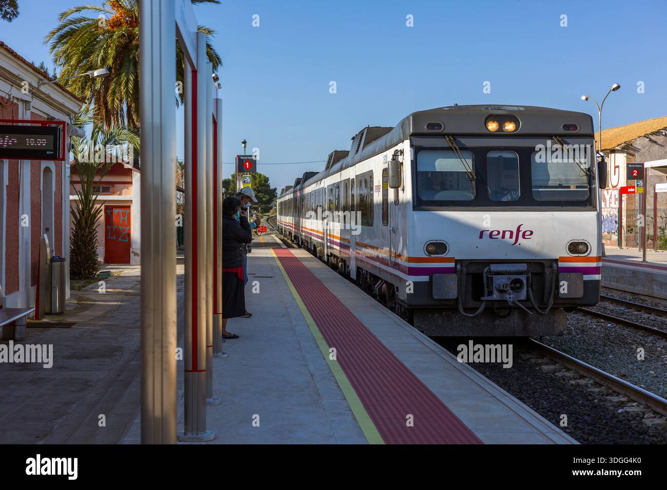 Torrellano, Spanien – 14. November 2021: Ein Regionalzug von Renfe, der am Bahnhof Torrellano ankommt und Elche nach Alicante verbindet, mit Passagieren, die auf den Bahnhof warten Stockfoto