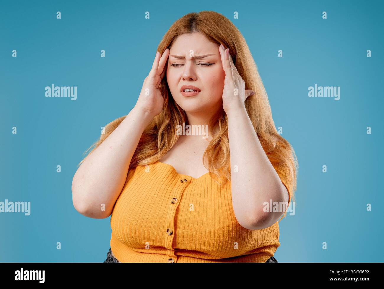 Plus Size Frau, Die Tempel Berührt, Leidet An Kopfschmerzen, Pink Studio. Schmerzen. Stockfoto