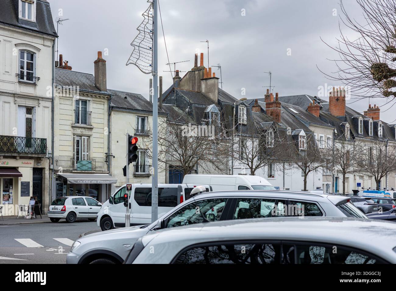Tours, Frankreich - 26. November 2021: Autos warten an der roten Ampel auf der Straße Place Rouget de Lisle in der Nähe historischer Steinhäuser und Geschäfte in Tours Fran Stockfoto