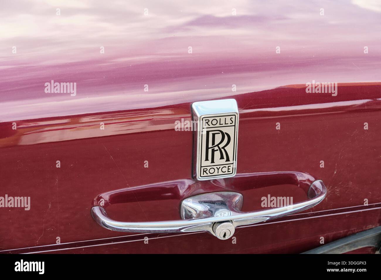 Malmö, Schweden - 7. August 2025: In einer Nahaufnahme werden die Verzierung und der Griff der Motorhaube eines klassischen Rolls Royce-Autos aufgenommen, die das Fahrzeug in kastanienbraunen Farben hervorheben Stockfoto