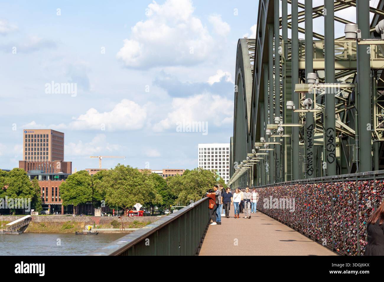 KÖLN, DEUTSCHLAND - 31. MAI 2024: Touristen spazieren entlang der Hohenzollernbrücke, berühmt für tausende Liebesschlösser am Zaun. Rhein an Stockfoto