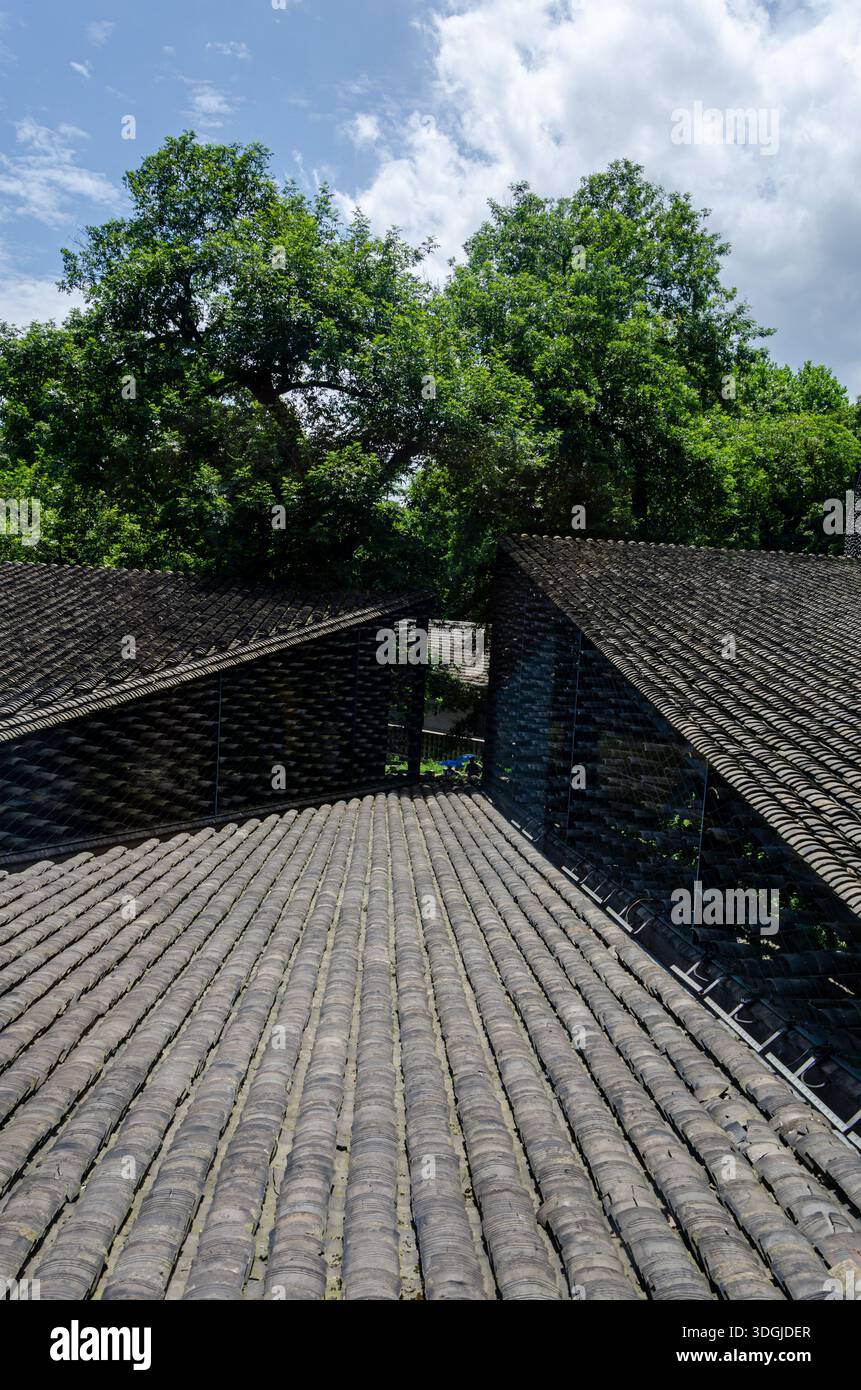 Vertikale Aufnahme mit Fokus auf Struktur und Geometrie von grauen Ziegeldächern. Die geneigten Winkel und die traditionellen Tonmaterialien werden in einem modernen Archit verwendet Stockfoto